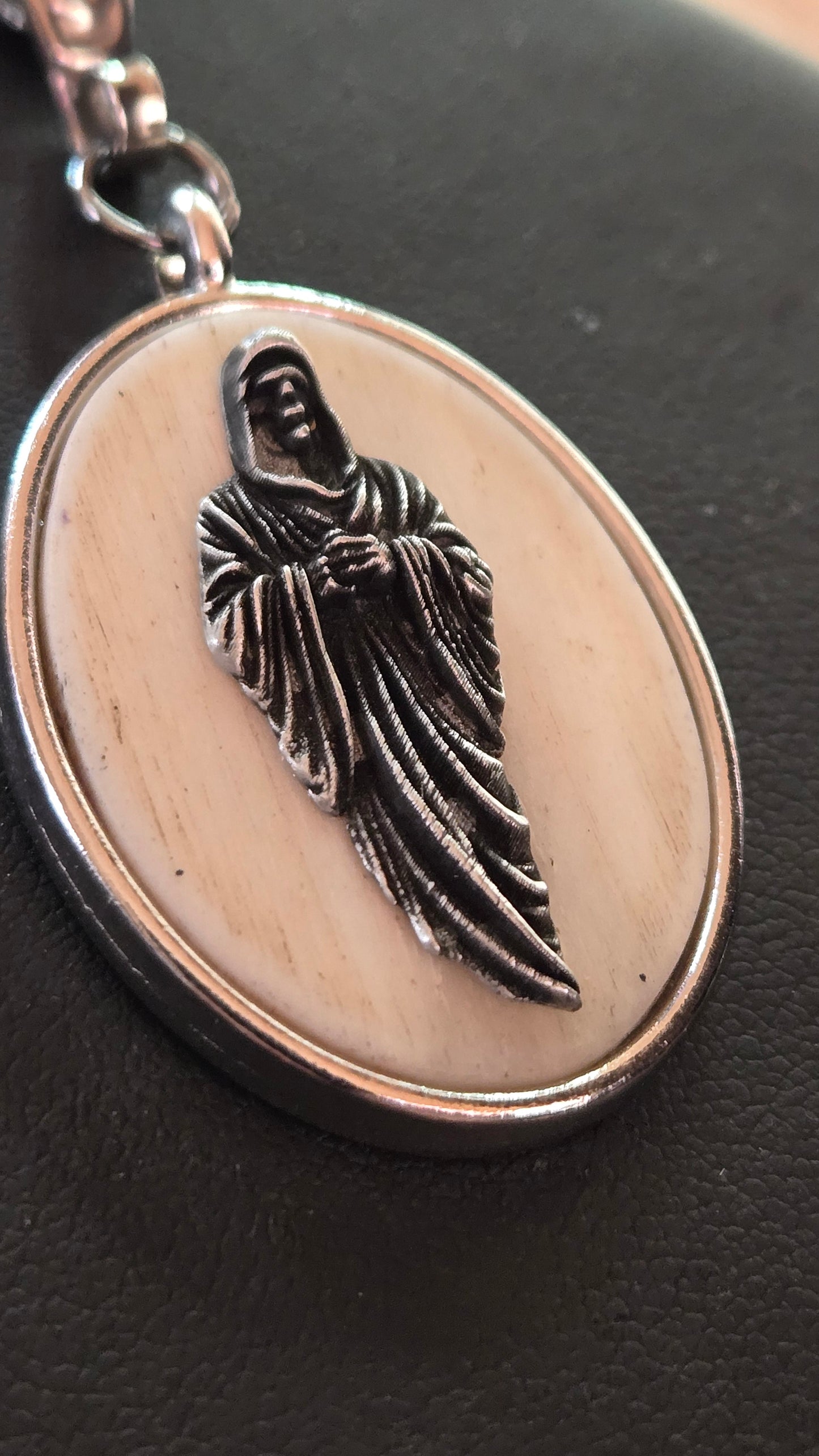 Hand-Shaped Human Bone Pendant with Engraved Reaper